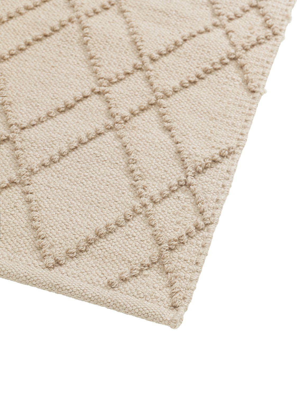 Alma matta i beige färg som tål regn placerad i en stilren miljö