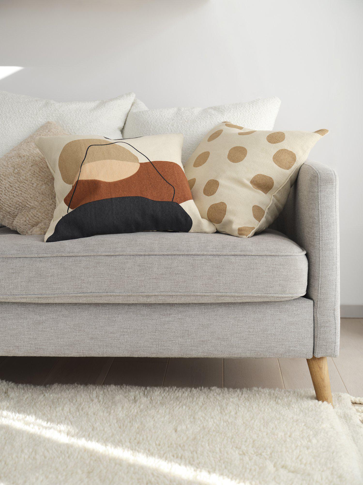 Dorte kuddfodral iskaffe placerat i en soffmiljö för inredningsinspiration