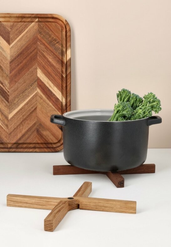 Grytunderlägg i mörk och ljus ek under kastrull i ett lantkök