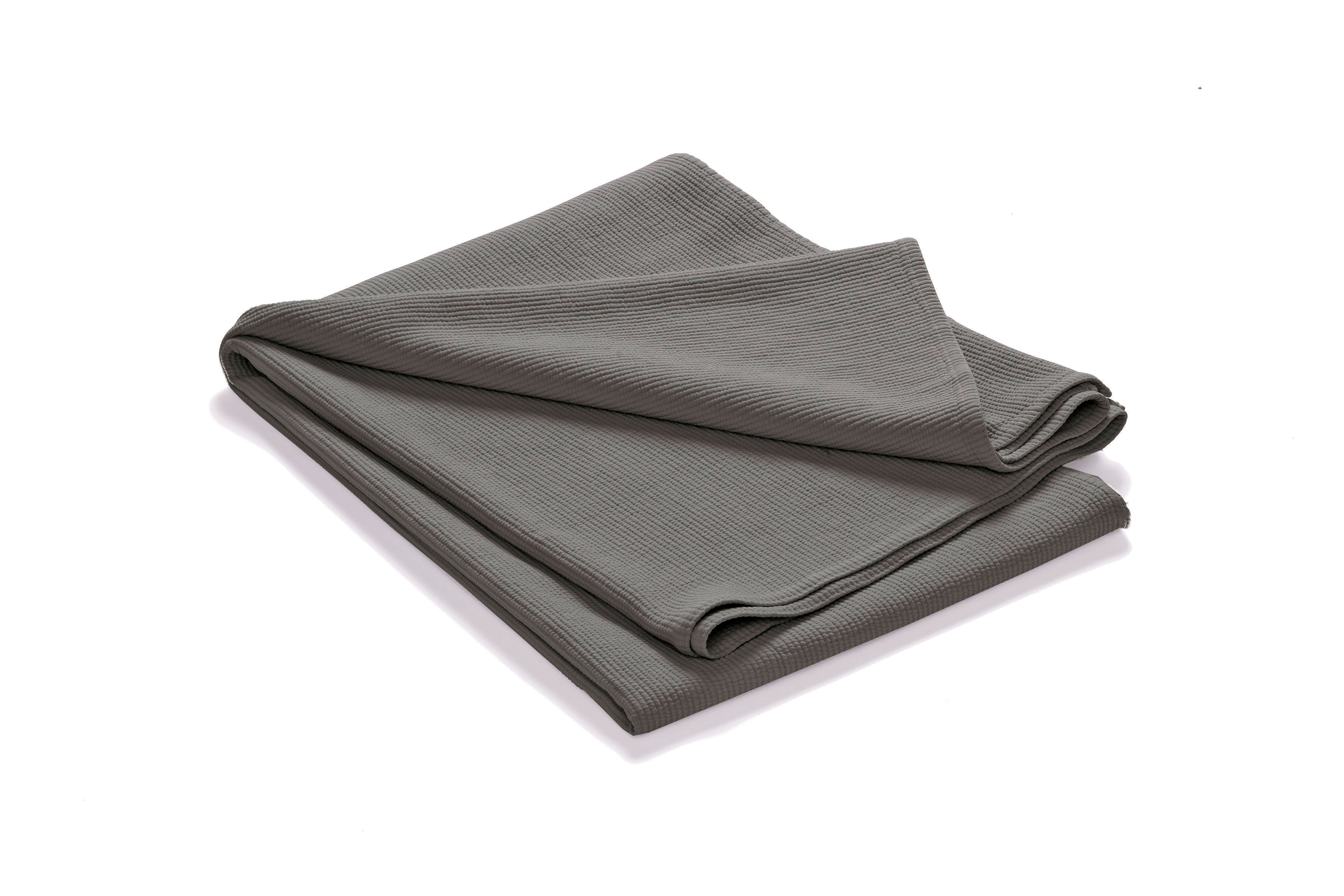 Mjukt mörkgrått överkast Stripes i stentvättad bomull, vikt mot vit bakgrund