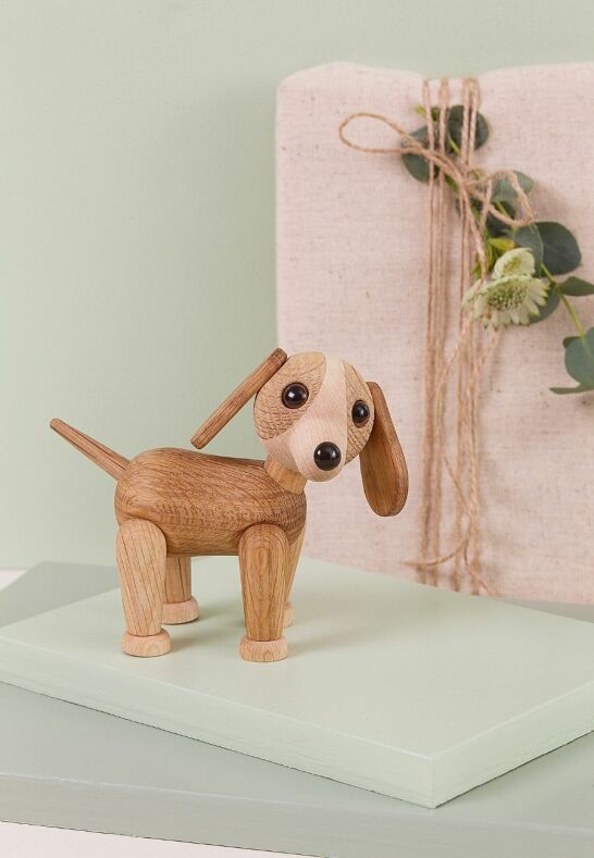 Trädekoration hund vid linnetextil och blommor i ett rofyllt gårdsliv