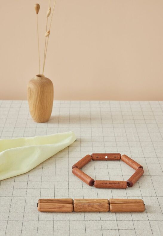 Närbild på Connect ihopfällbart grytunderlägg i mörkt trämaterial med magnetisk stängning