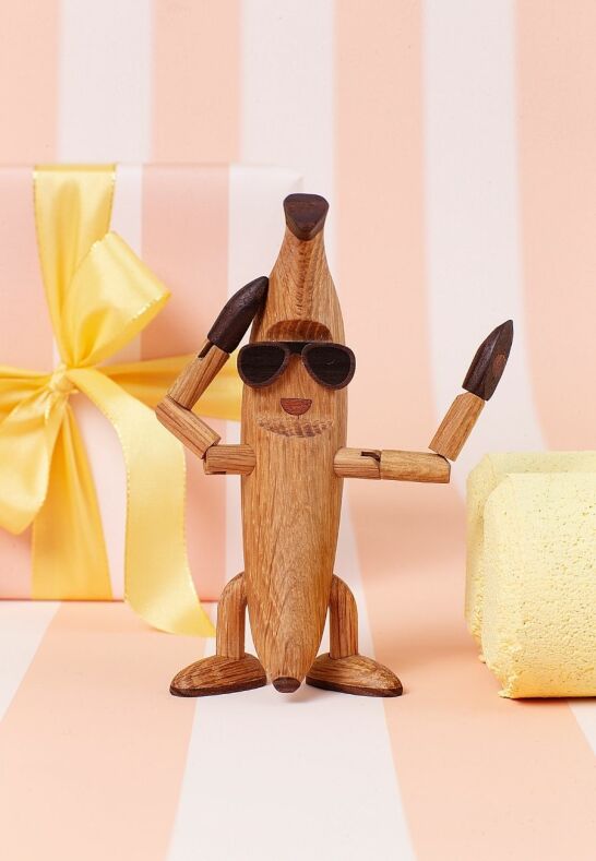 Trädekoration Benny Banana framför rosa bakgrund – personlig present till stugan