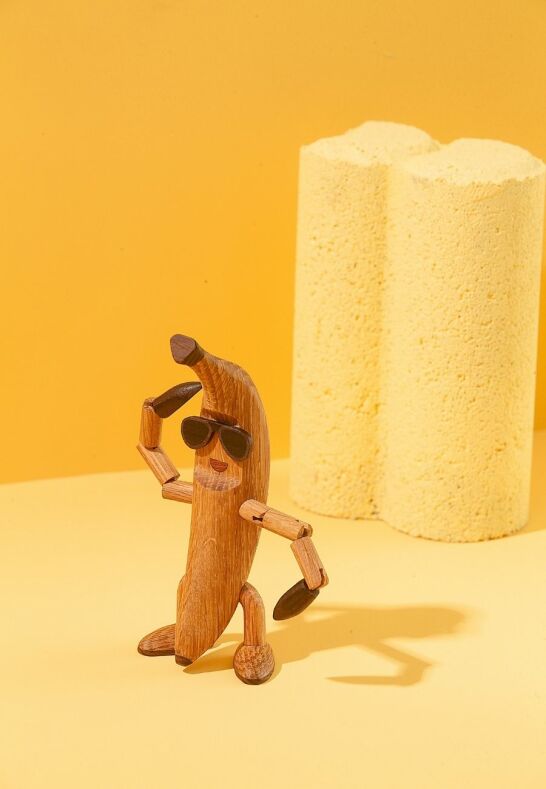 Benny Banana figur i FSC-certifierad ek på gul bakgrund för lekfullt gårdsliv