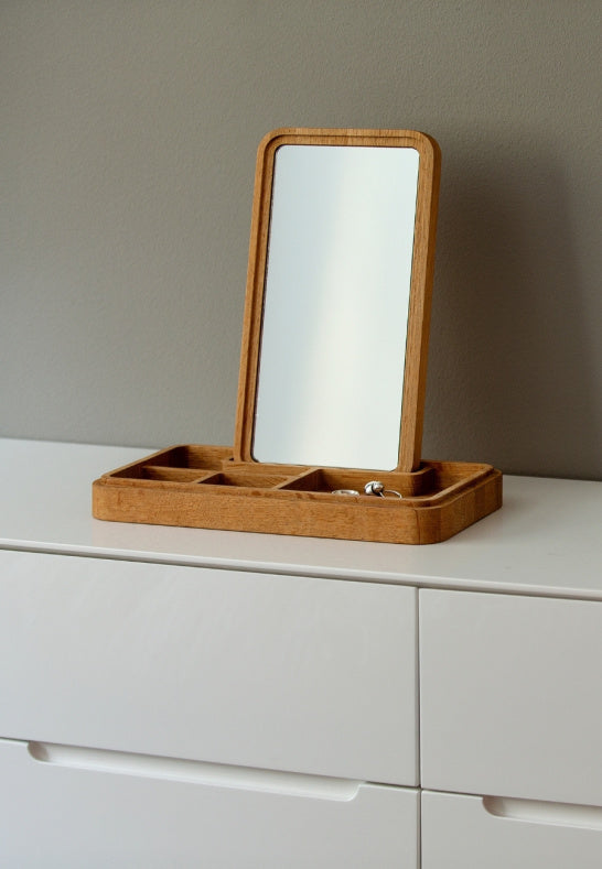 Tidlöst ekrör med spegel för småsaker placerat på en vit modern byrå
