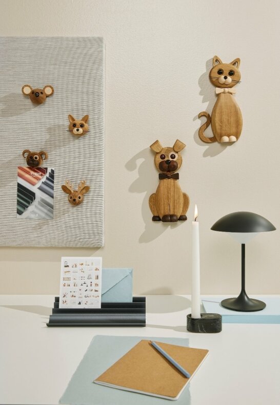 Trämagneter föreställande olika djur på en anslagstavla i ett lantligt arbetsrum