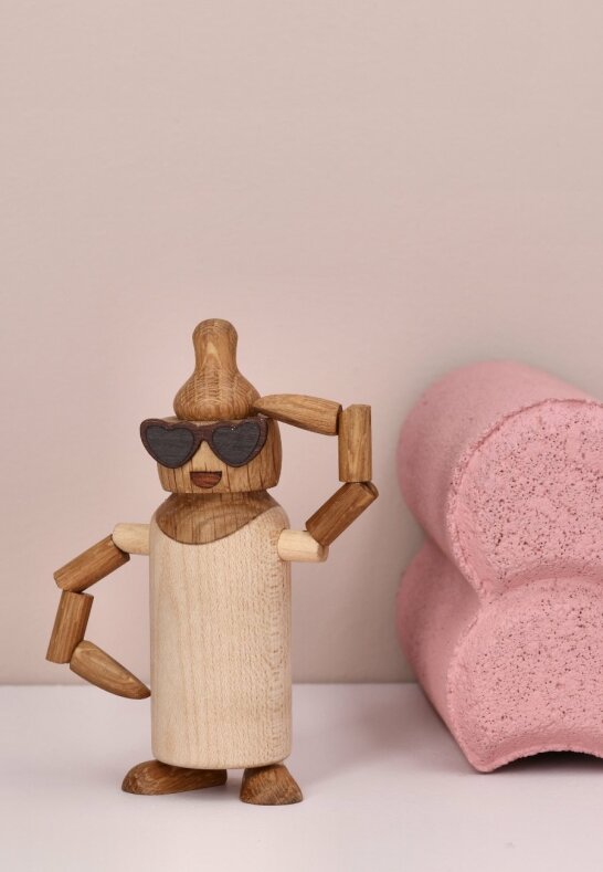 Dekorativ träflaska Billie i lönn intill rosa inredningsdetalj för barnrummet