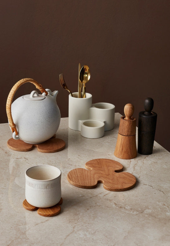 Dukning med saltkvarn i ek och keramik på ett rustikt bord