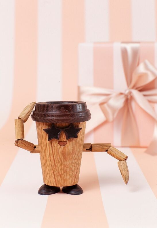 Presenttips till kaffeälskaren: Esther Espresso träfigur framför ett ljusrosa paket